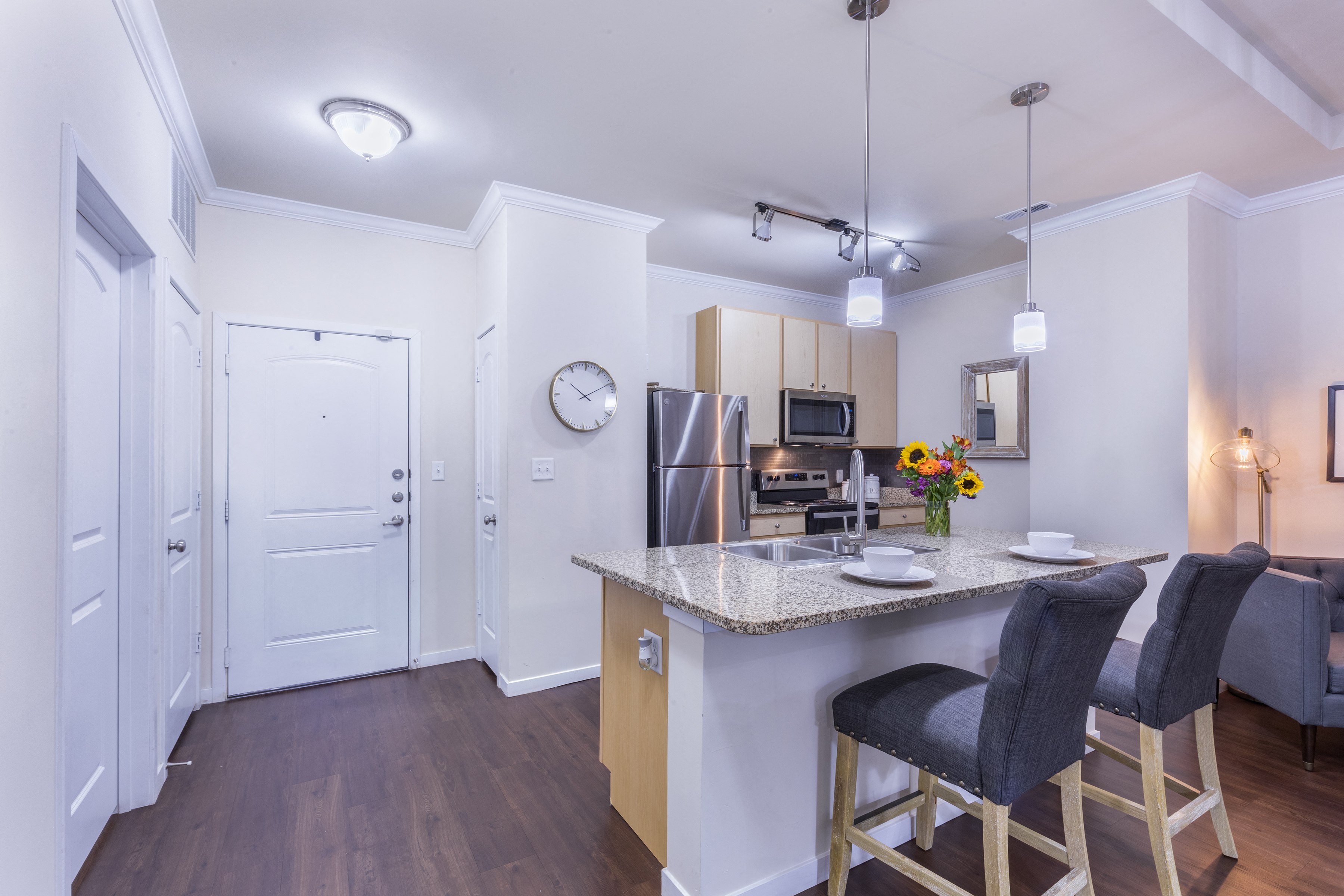 a kitchen and living room with a marble counter top and bar stools at Aventura at Forest Park, St.Louis, MO